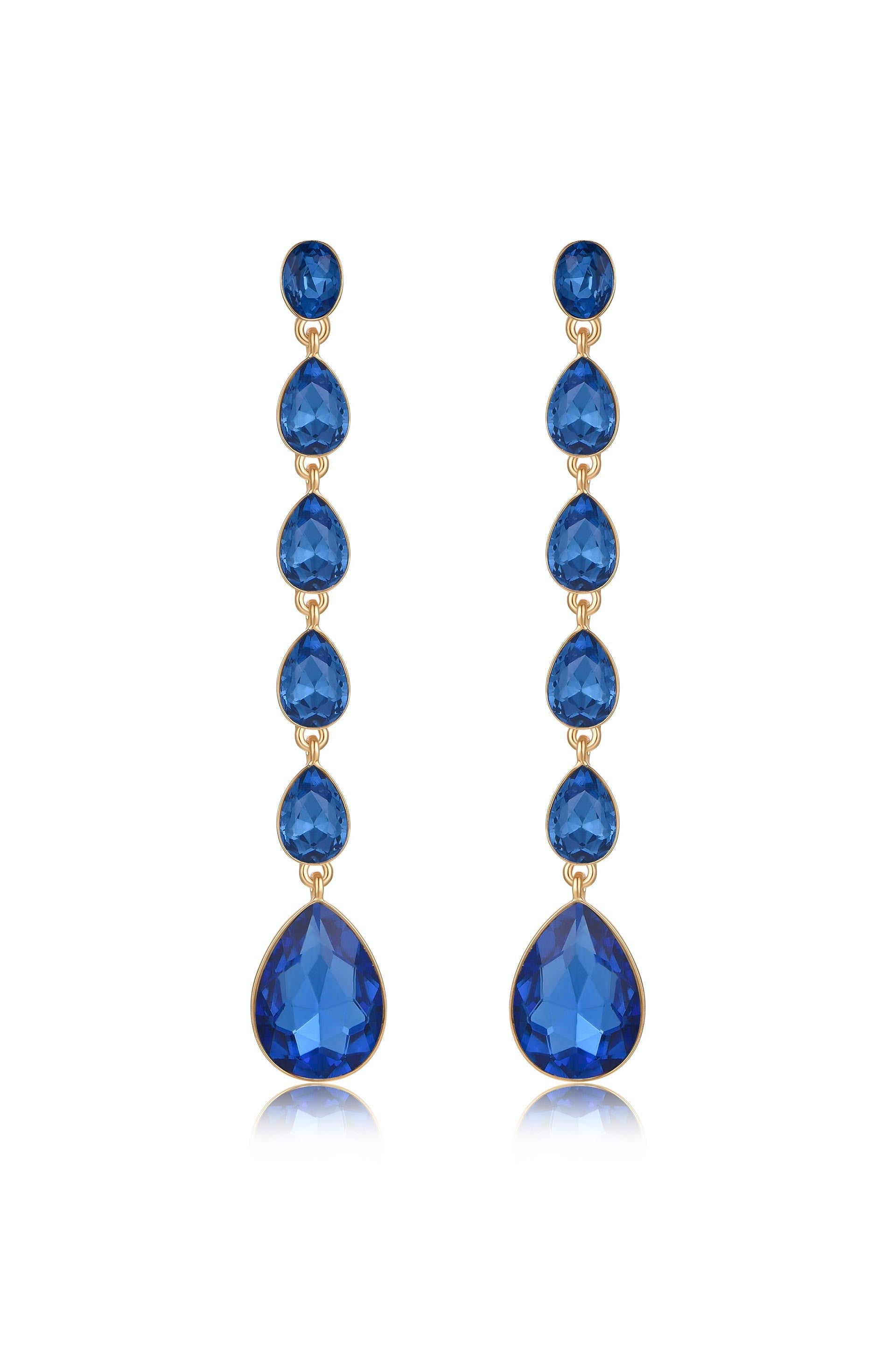 Dangle earrings feature multiple blue gemstones in teardrop and round shapes, strung together in a vertical arrangement. They are set against a plain white background, enhancing their elegance.