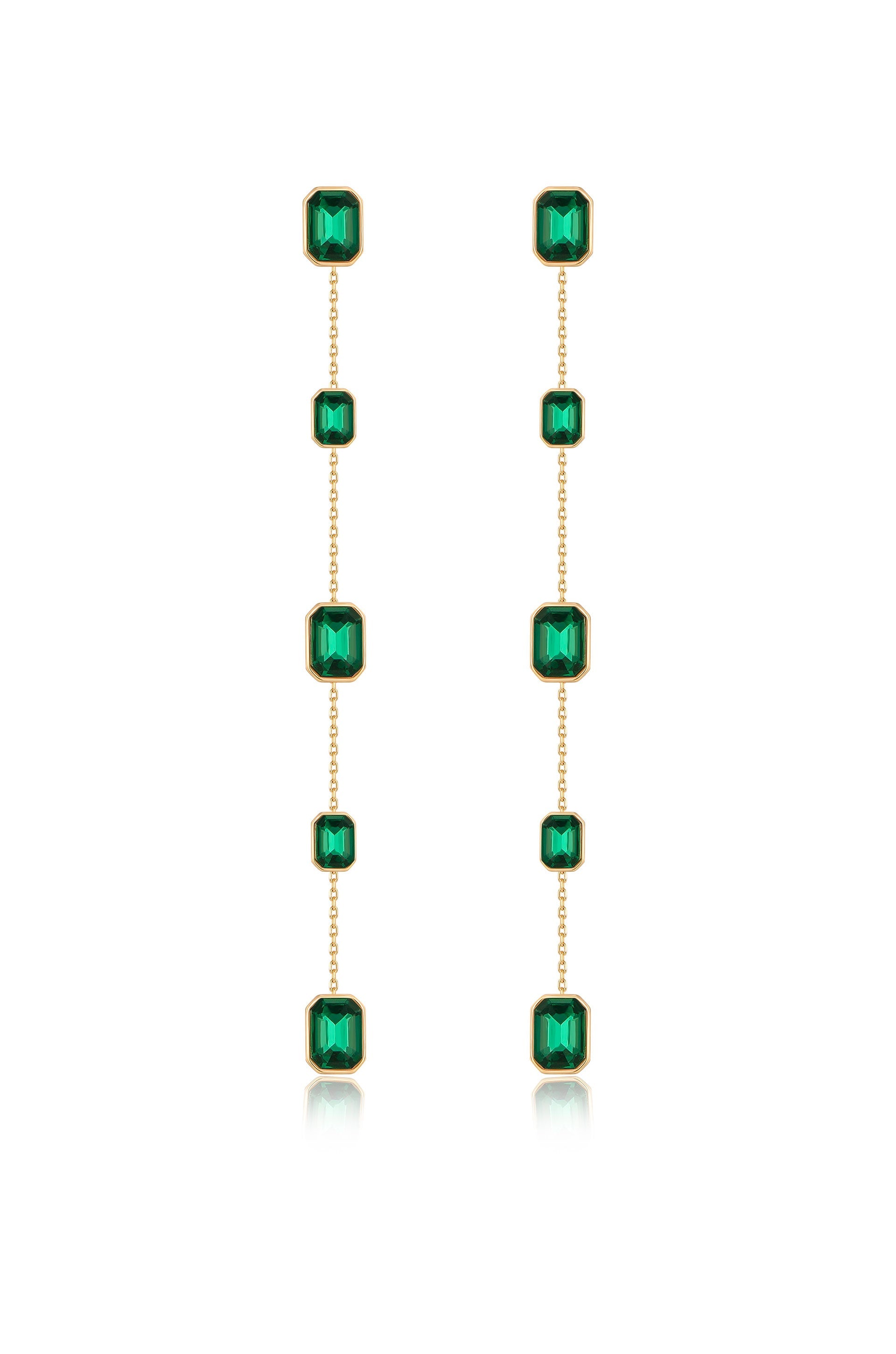 Two dangling earrings are displayed, featuring a series of rectangular green gemstones set in gold. They hang vertically, reflecting light against a white background.