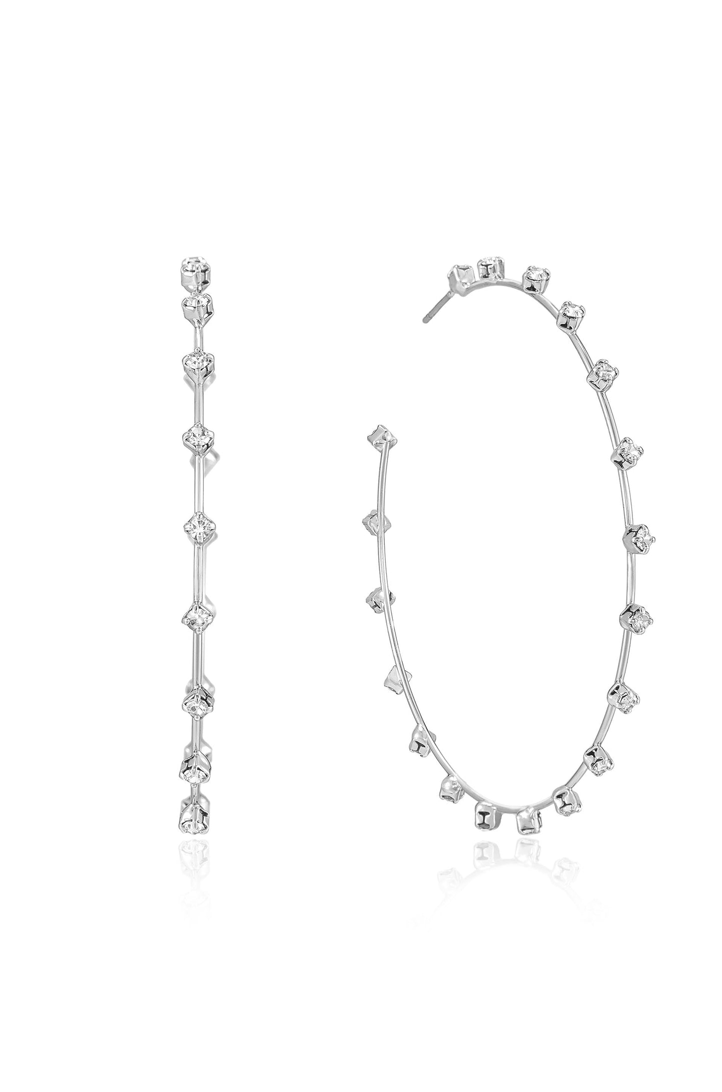 Two elegant silver earrings are displayed; one is a straight stud design with alternating clear gemstones, while the other is a circular hoop adorned with a symmetrical arrangement of the same gemstones.