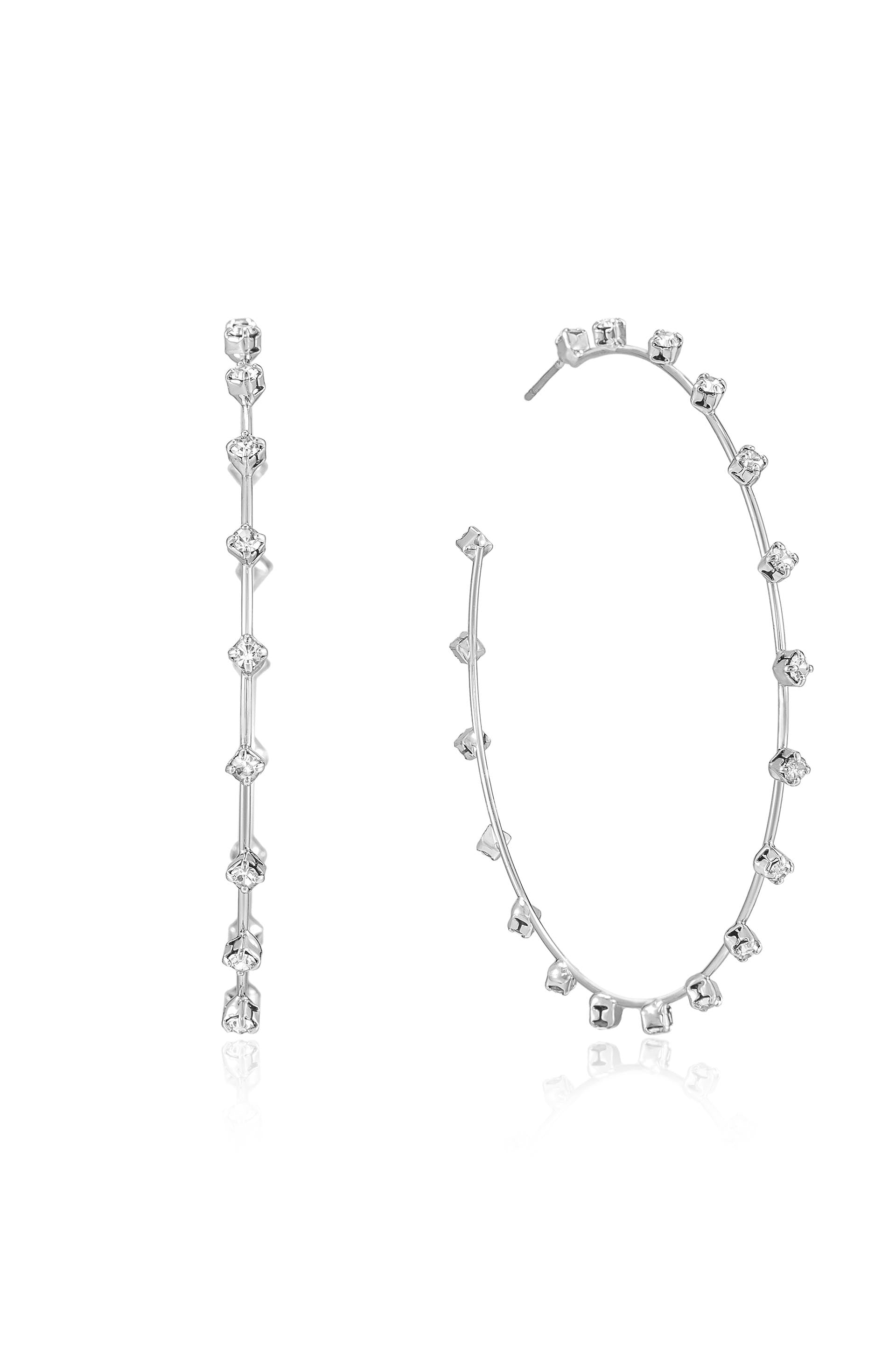 Two elegant silver earrings are displayed; one is a straight stud design with alternating clear gemstones, while the other is a circular hoop adorned with a symmetrical arrangement of the same gemstones.