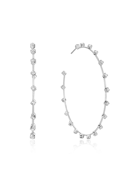 Two elegant silver earrings are displayed; one is a straight stud design with alternating clear gemstones, while the other is a circular hoop adorned with a symmetrical arrangement of the same gemstones.