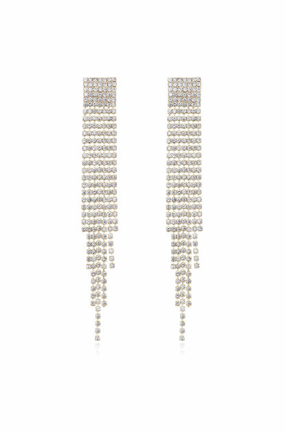 Sparkling dangle earrings hang vertically, featuring a series of shiny rhinestones arranged in cascading rows. The background is plain white, highlighting the earrings' elegance and shine.