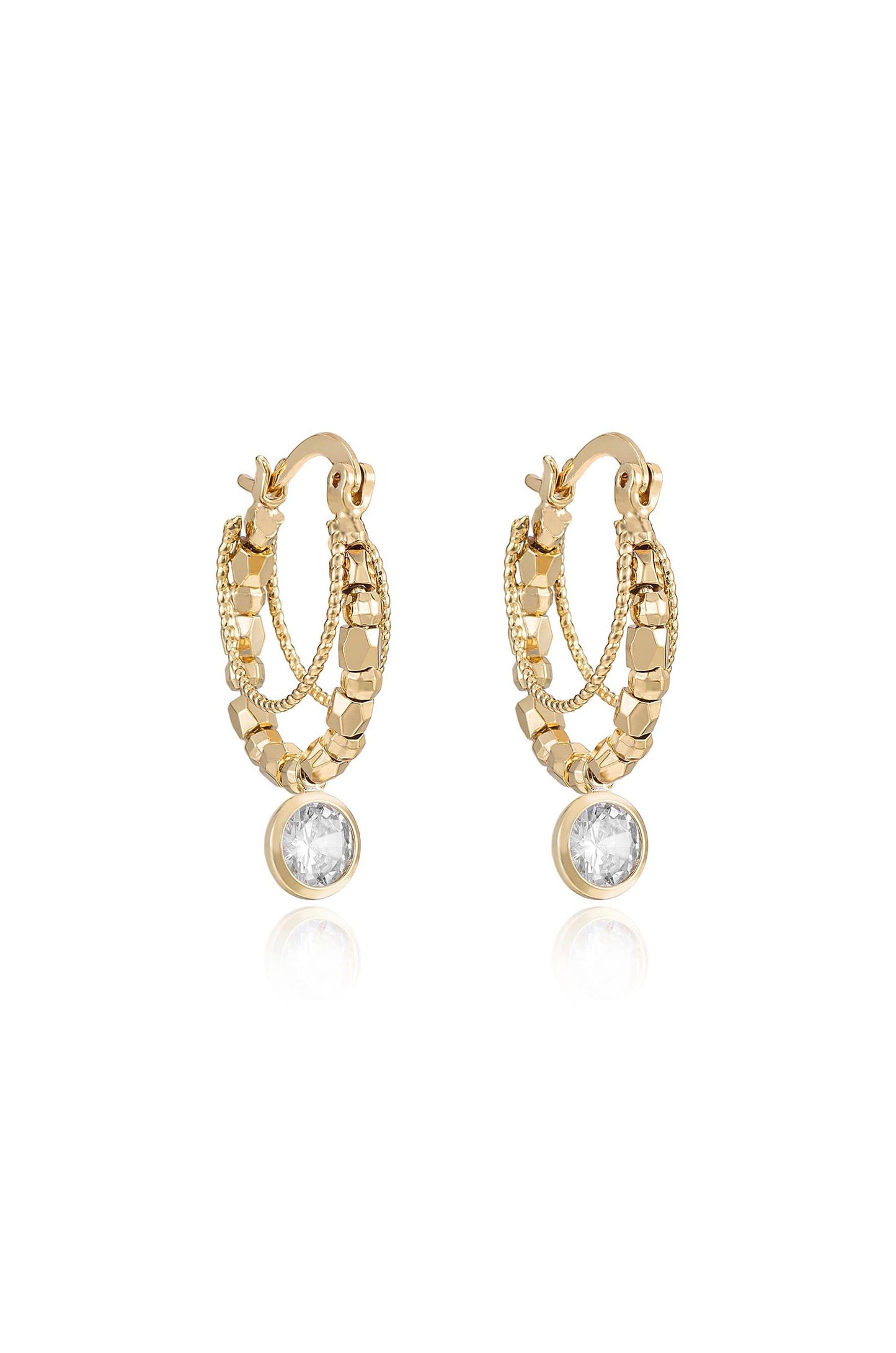 Gold hoop earrings feature intricate chain and bead detailing, with a single clear gemstone at the bottom, reflecting light, set against a neutral backdrop.