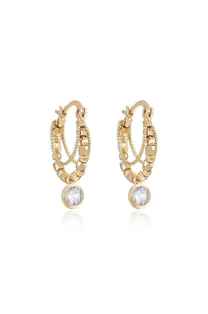 Gold hoop earrings feature intricate chain and bead detailing, with a single clear gemstone at the bottom, reflecting light, set against a neutral backdrop.