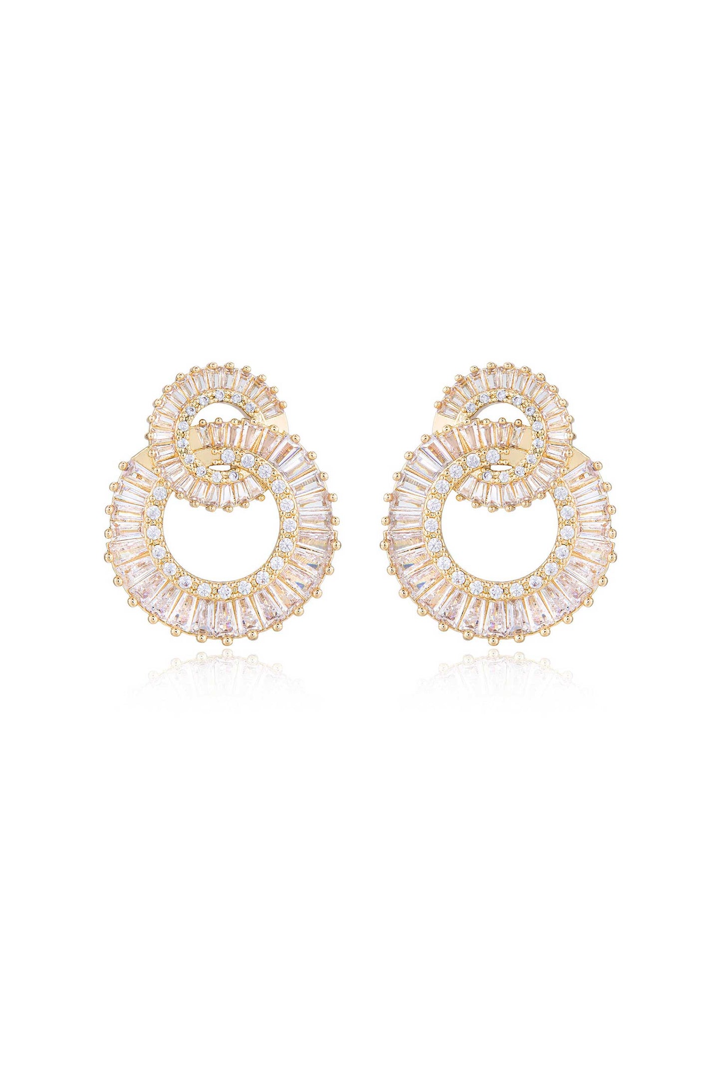 Golden hoop earrings with intricate patterns feature a spiral design filled with sparkling gemstones. They are displayed on a reflective surface, enhancing their elegance and shine.