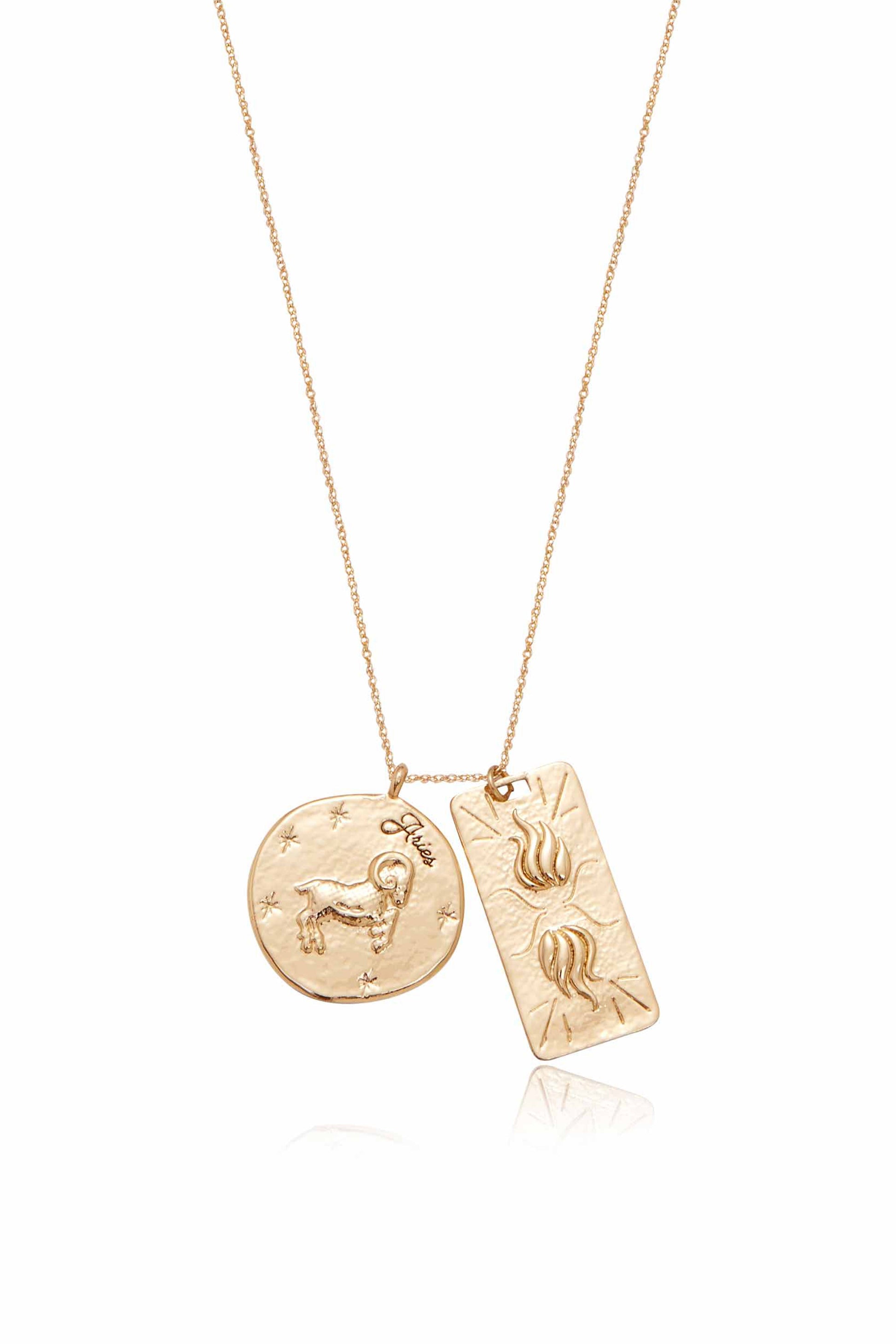 A gold necklace features two pendants: a round one with a ram and â€œAriesâ€ inscribed, and a rectangular one with stylized flames, both hanging from a delicate chain against a white background.