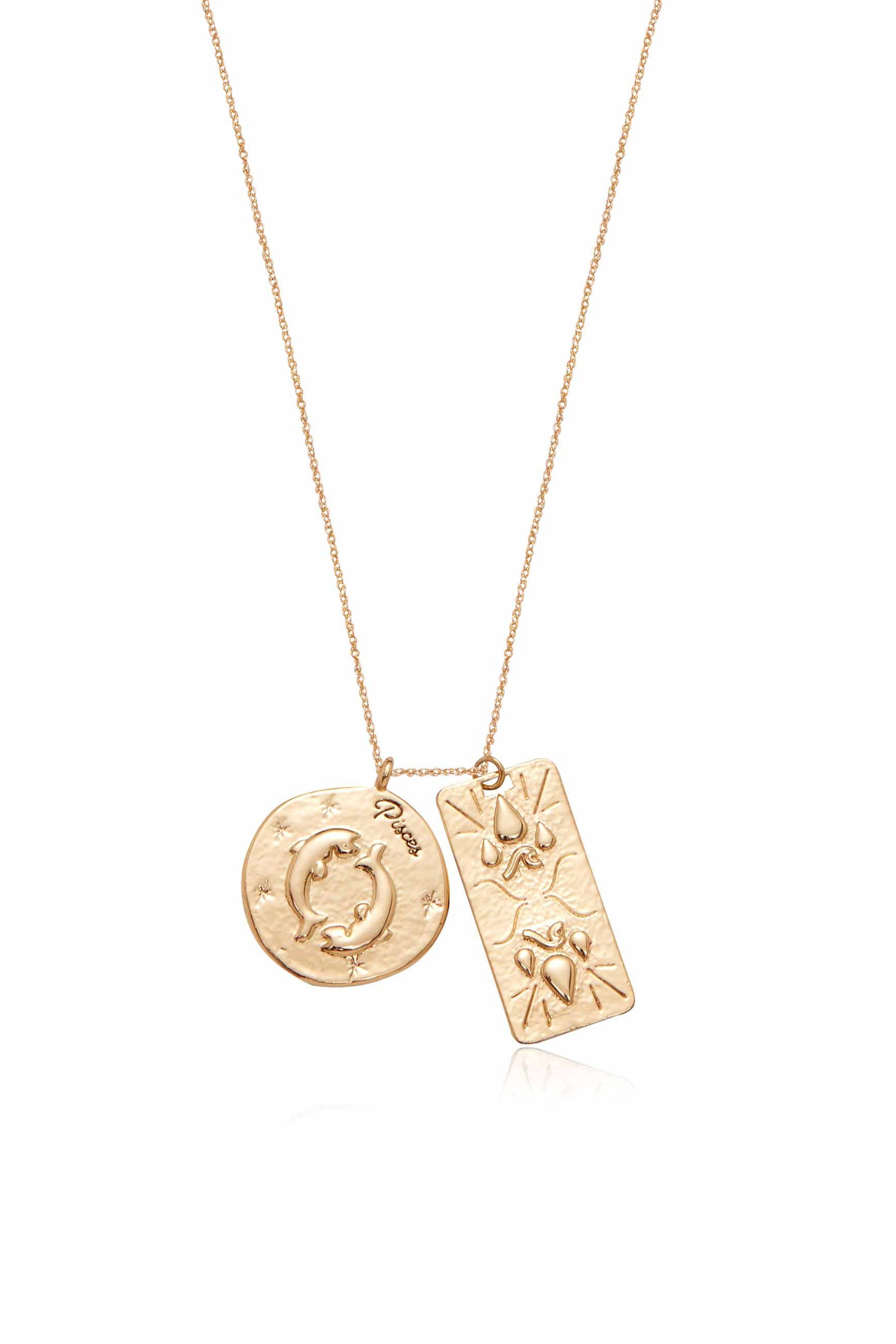 A gold necklace features two pendants: a circular one with the word "Pisces" and depicted dolphins, and a rectangular one with drop and wave patterns.