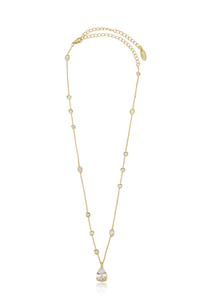 A gold chain necklace features multiple small, clear gemstones along its length, culminating in a larger, pear-shaped gemstone pendant that hangs centrally. The background is plain and unobtrusive.