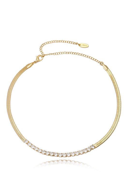 A gold necklace adorned with a row of sparkling stones. The chain is sleek and thin, highlighting the elegant design against a plain white background.