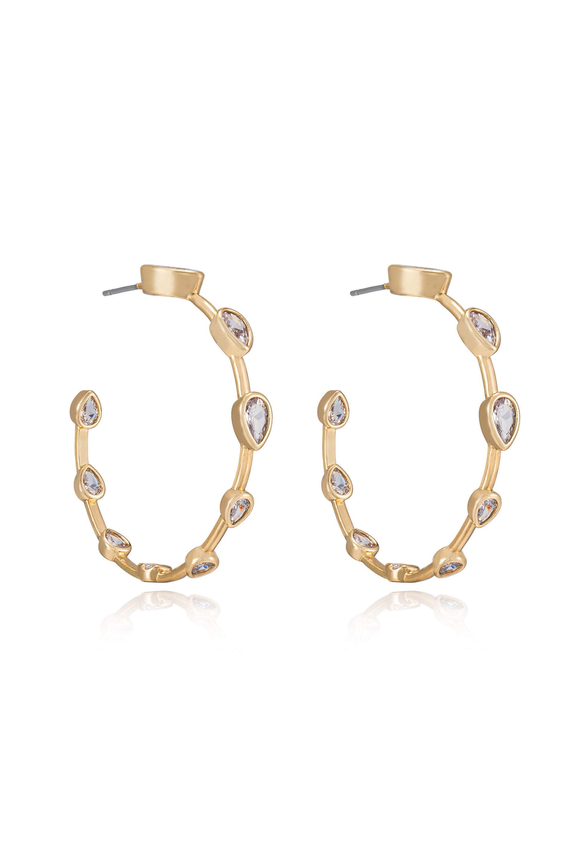 Gold hoop earrings embellished with teardrop-shaped stones are displayed. The earrings reflect light and shimmer against a white background, showcasing their elegant design and detailing.