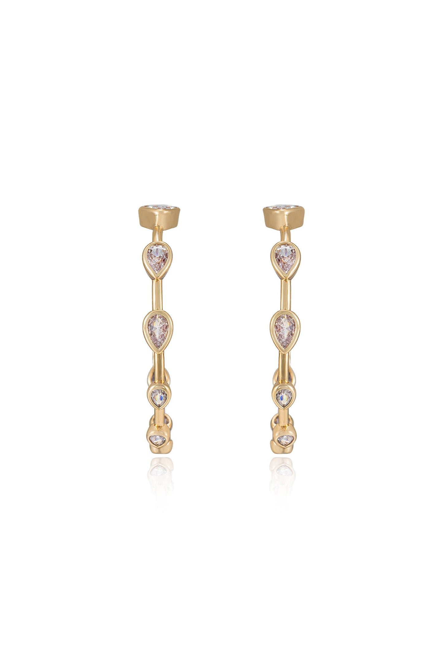 Two gold earrings feature a linear design adorned with teardrop and round stones. They are positioned upright against a reflective surface, showcasing their elegance and shine.