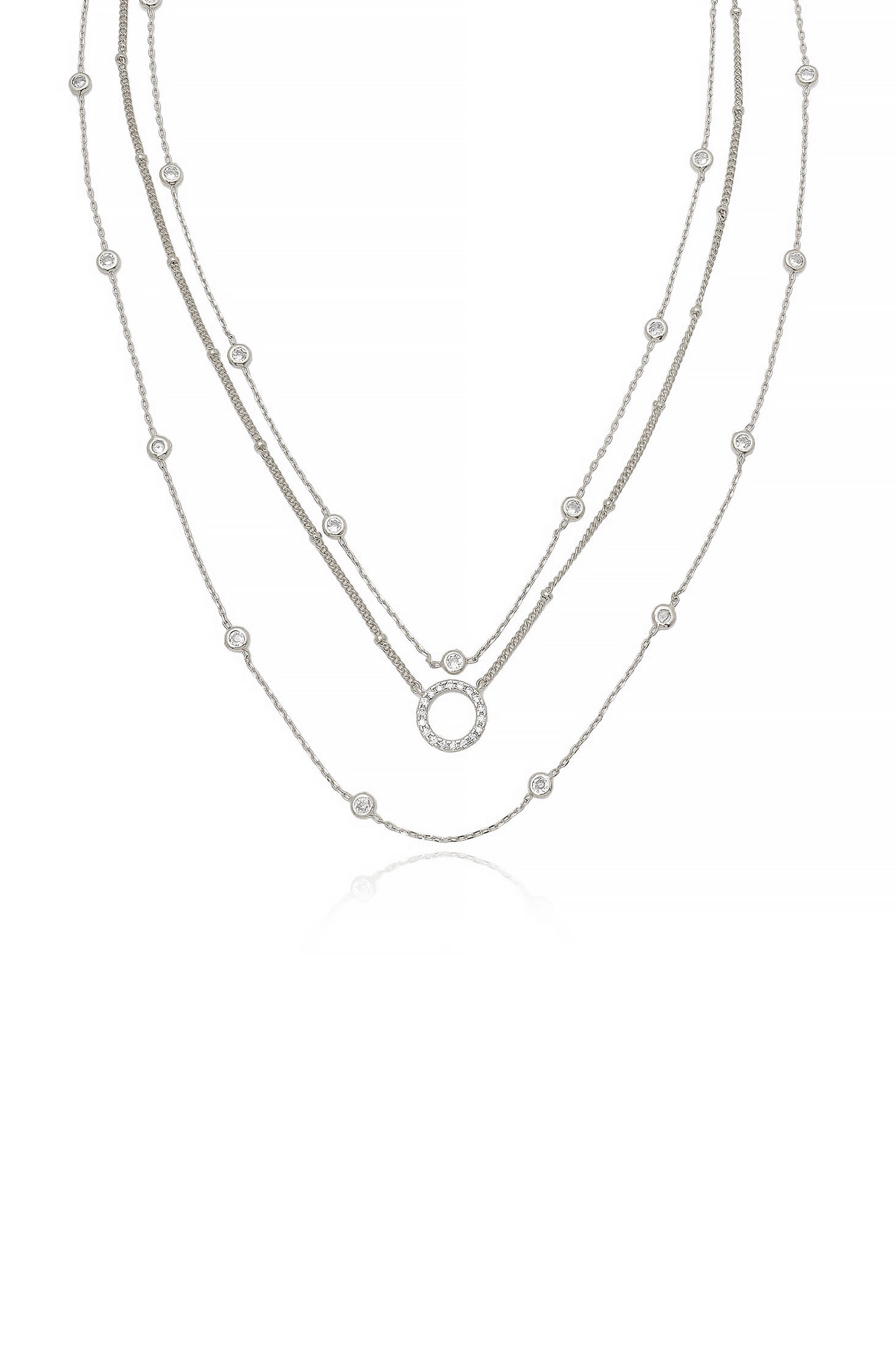 Three delicate silver chains adorn a display, each featuring small, sparkling diamond-like accents. The chains are layered in a descending fashion against a plain white background, showcasing elegance.