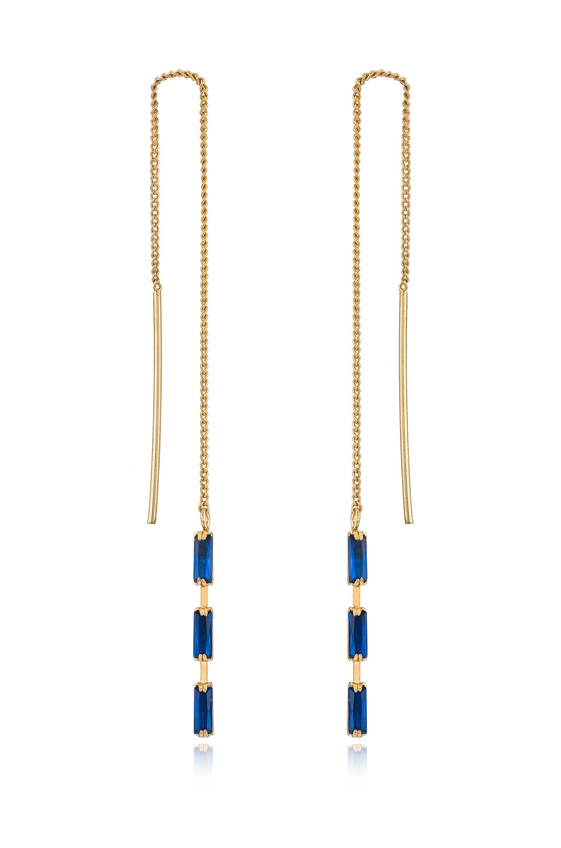 Earrings with a delicate gold chain feature three rectangular blue gemstones arranged vertically. The earrings hang elegantly, reflecting light against a neutral background.