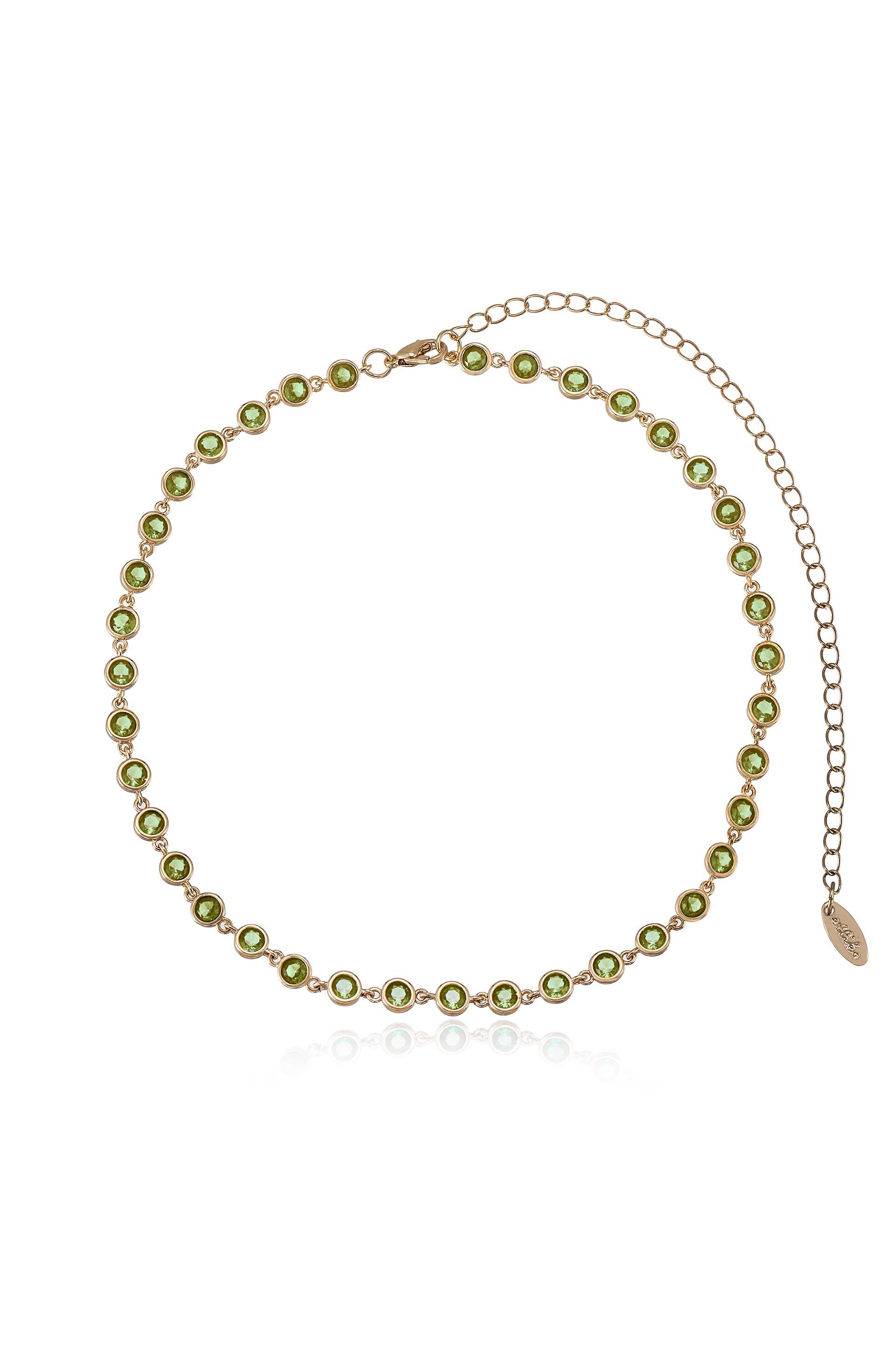 A gold necklace features a series of circular green gems set in a delicate chain, showcasing a shiny, polished appearance against a neutral background. It includes an adjustable clasp and extension chain.