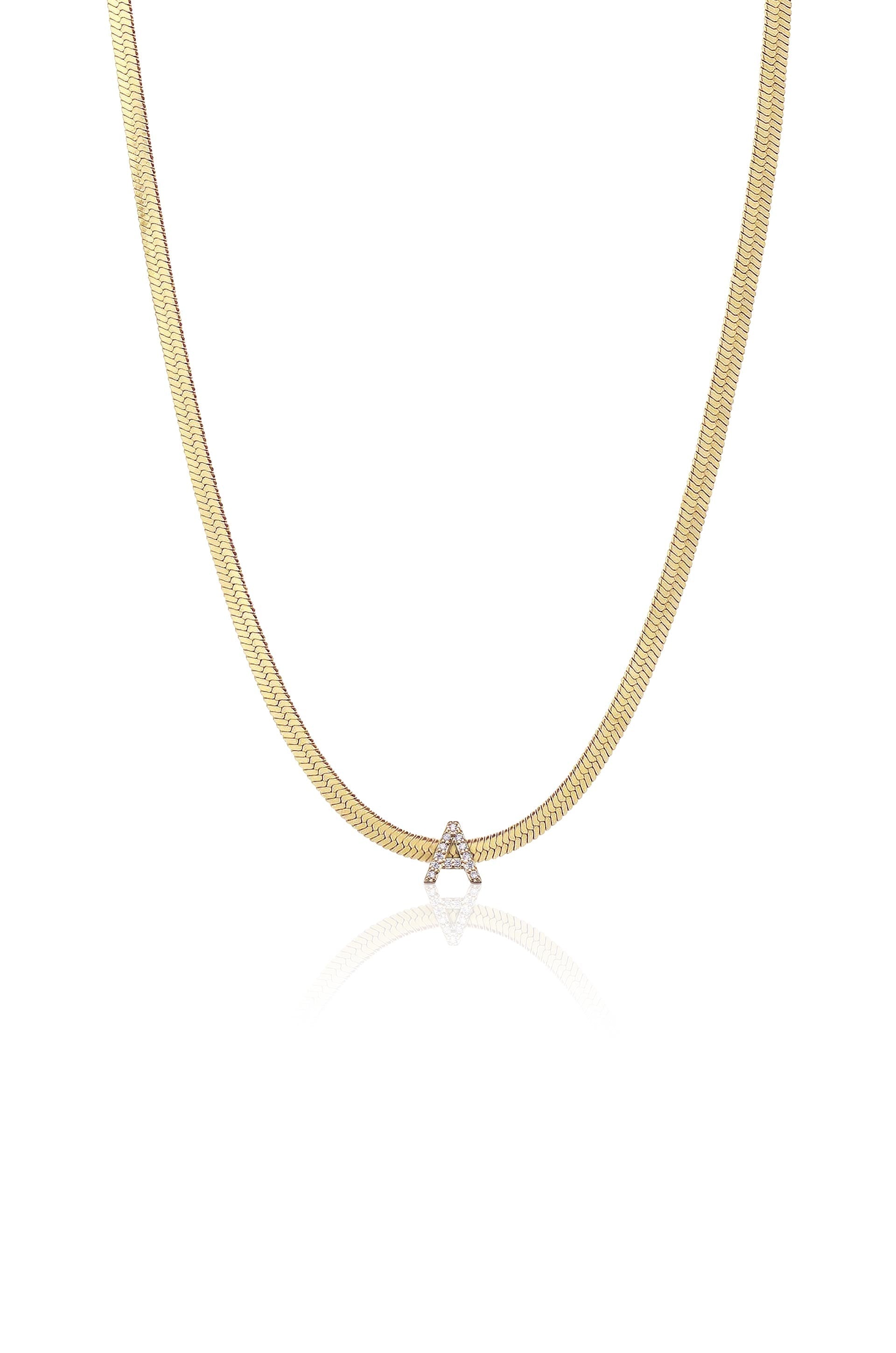 A gold chain necklace features a shimmering letter "A" embellished with diamonds, displayed against a plain white background that highlights its elegant design and reflective qualities.