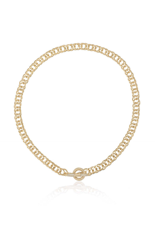 A gold chain necklace featuring interlocking links and a decorative clasp, positioned flat against a neutral surface that reflects its polished finish, enhancing its elegance and shine.