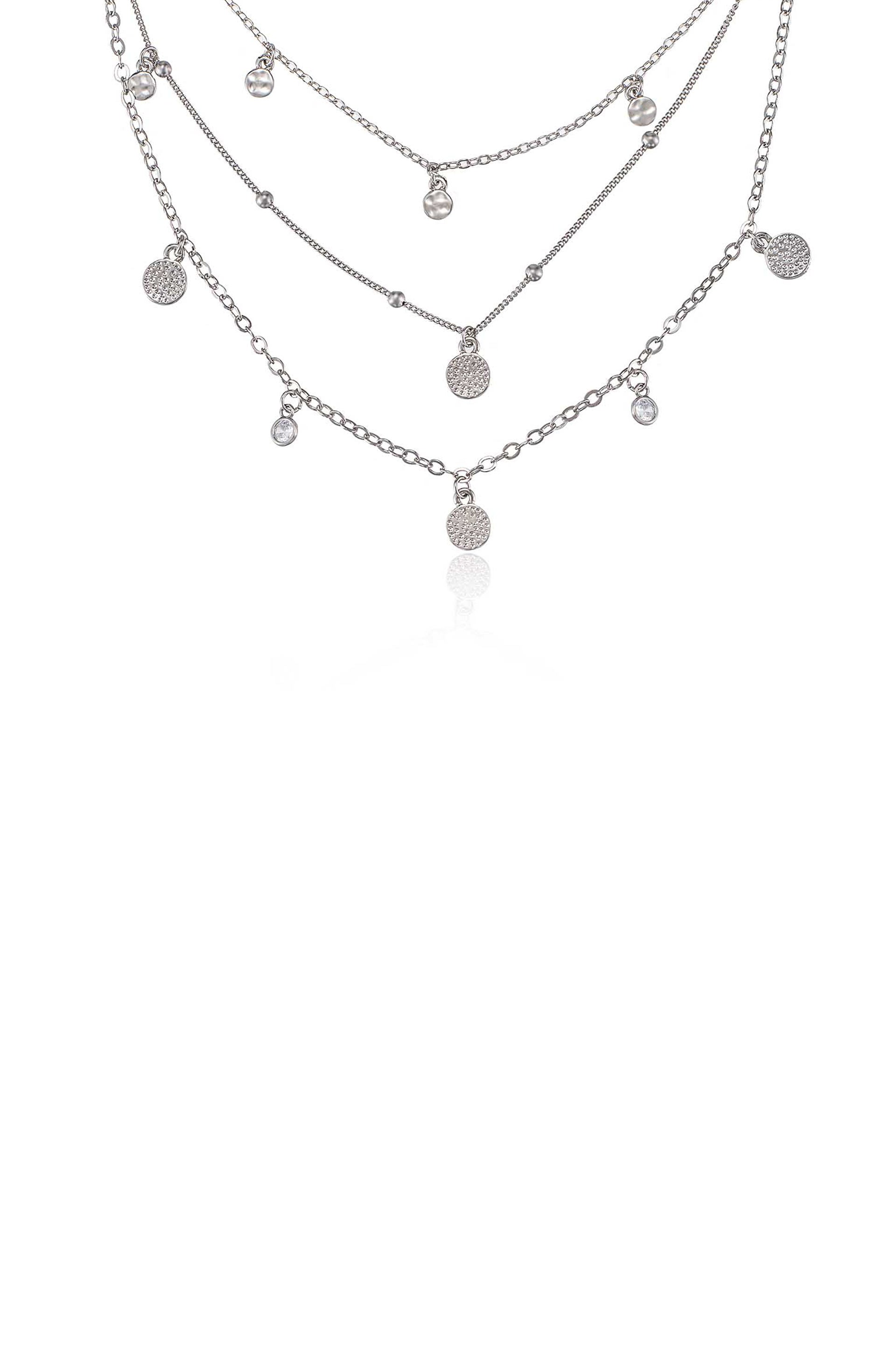 A silver necklace with multiple layered chains features various small pendants, including textured circles and clear beads, displayed against a white background.