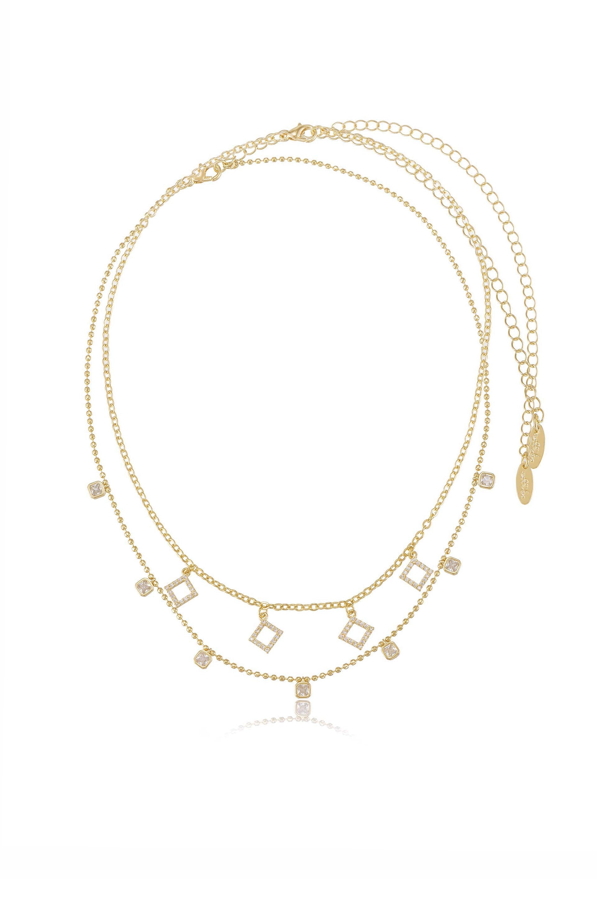 A multi-layer gold necklace features interconnected chains decorated with small square-shaped pendants, some embellished with sparkling stones, displayed against a plain white background.