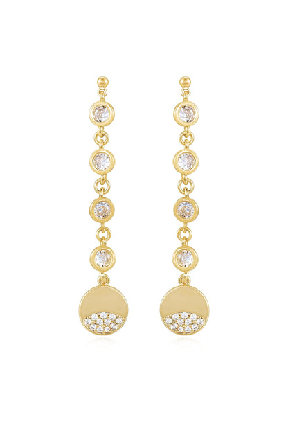 Gold earrings feature dangling elements with circular designs. Each earring has several sparkling gems arranged along the chain, culminating in a round disc adorned with smaller stones at the bottom.