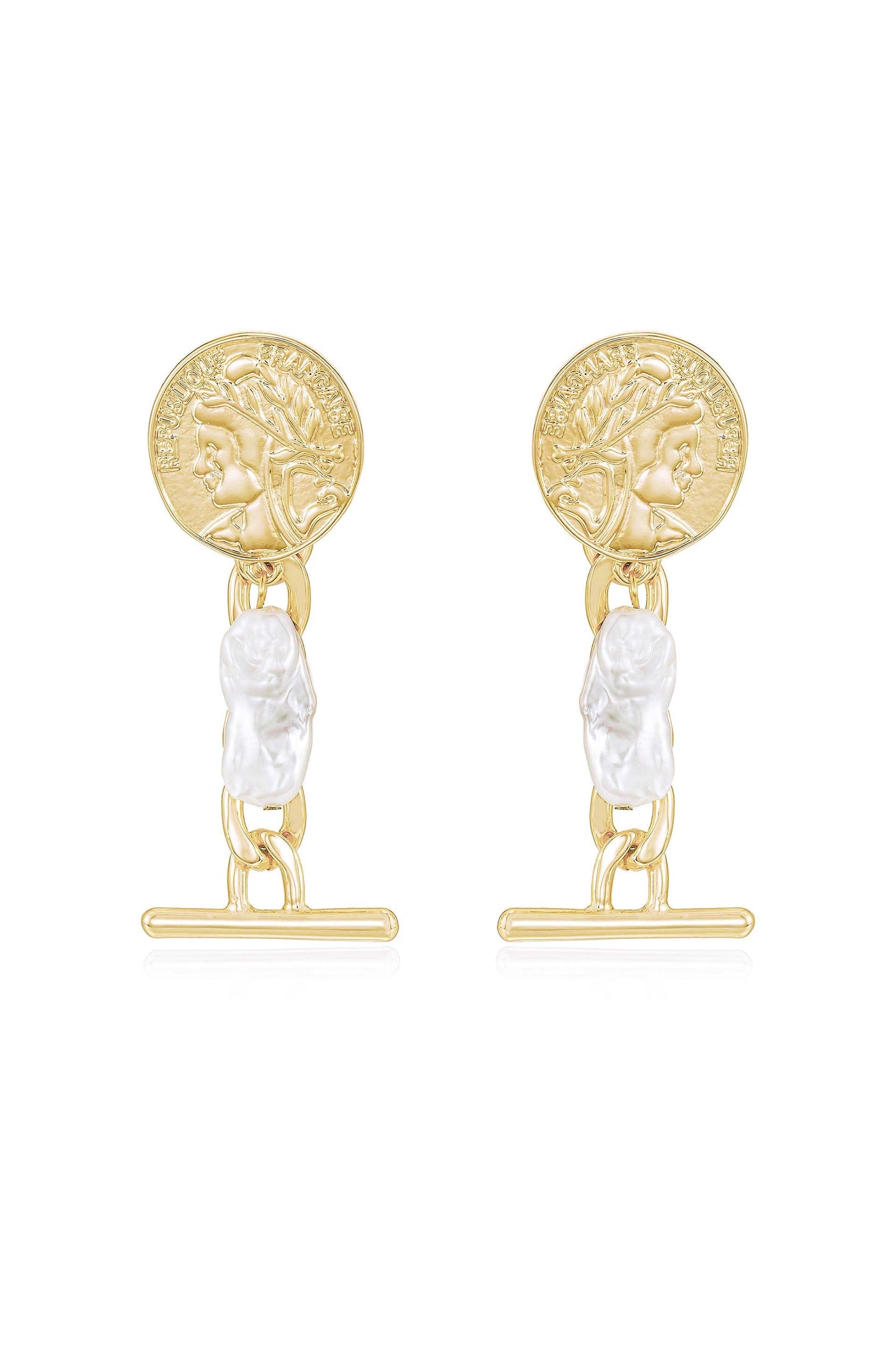 Gold-colored earrings feature a round coin with a profile design, linked by a chain to a carved white pearl-like piece. They are displayed against a neutral background.