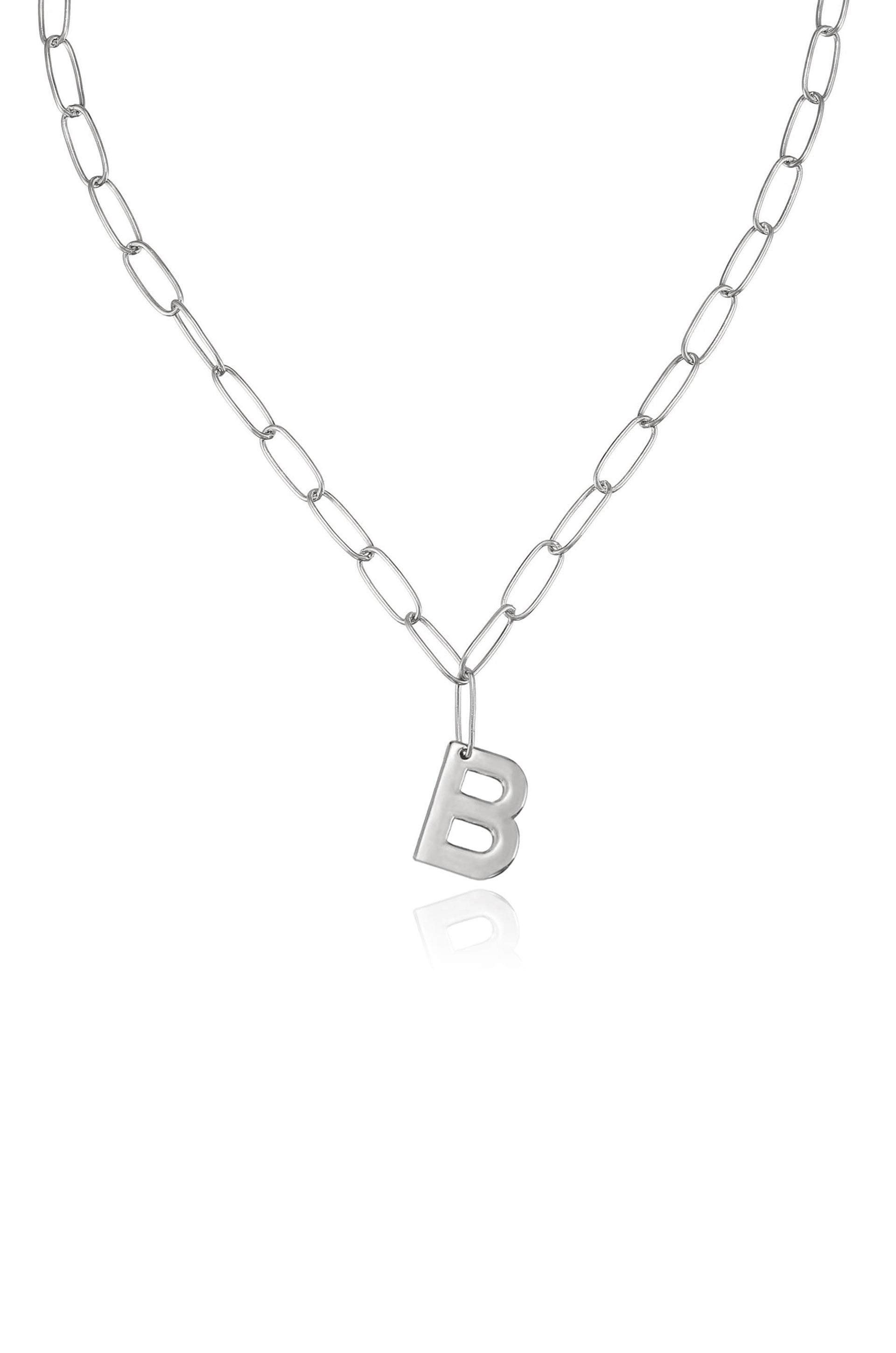 A silver chain necklace features elongated links with a metallic letter "B" pendant hanging in the center, set against a plain, bright background.