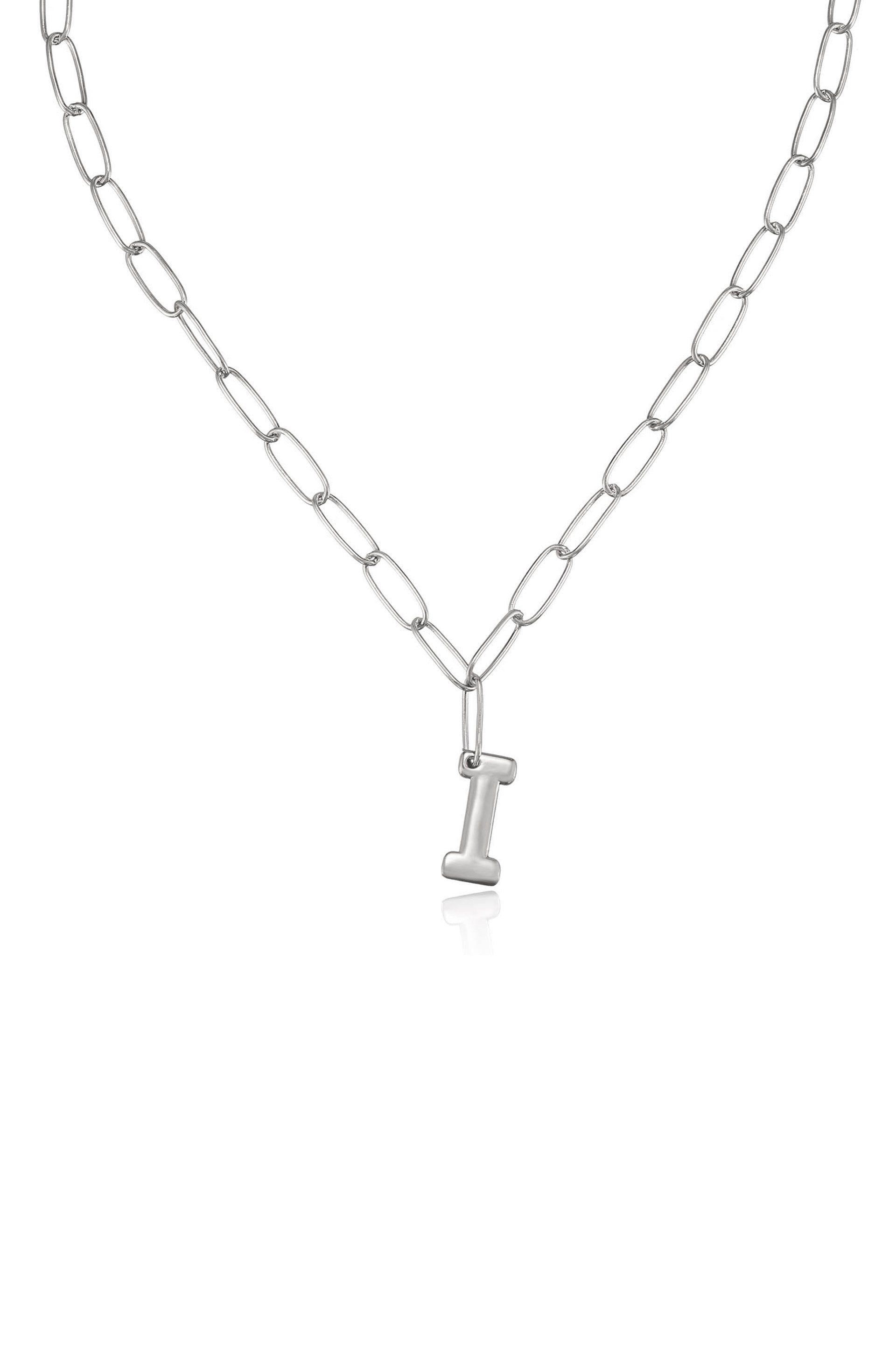 A silver chain necklace features elongated links and a prominent letter "I" pendant hanging delicately at its center, set against a plain white background.