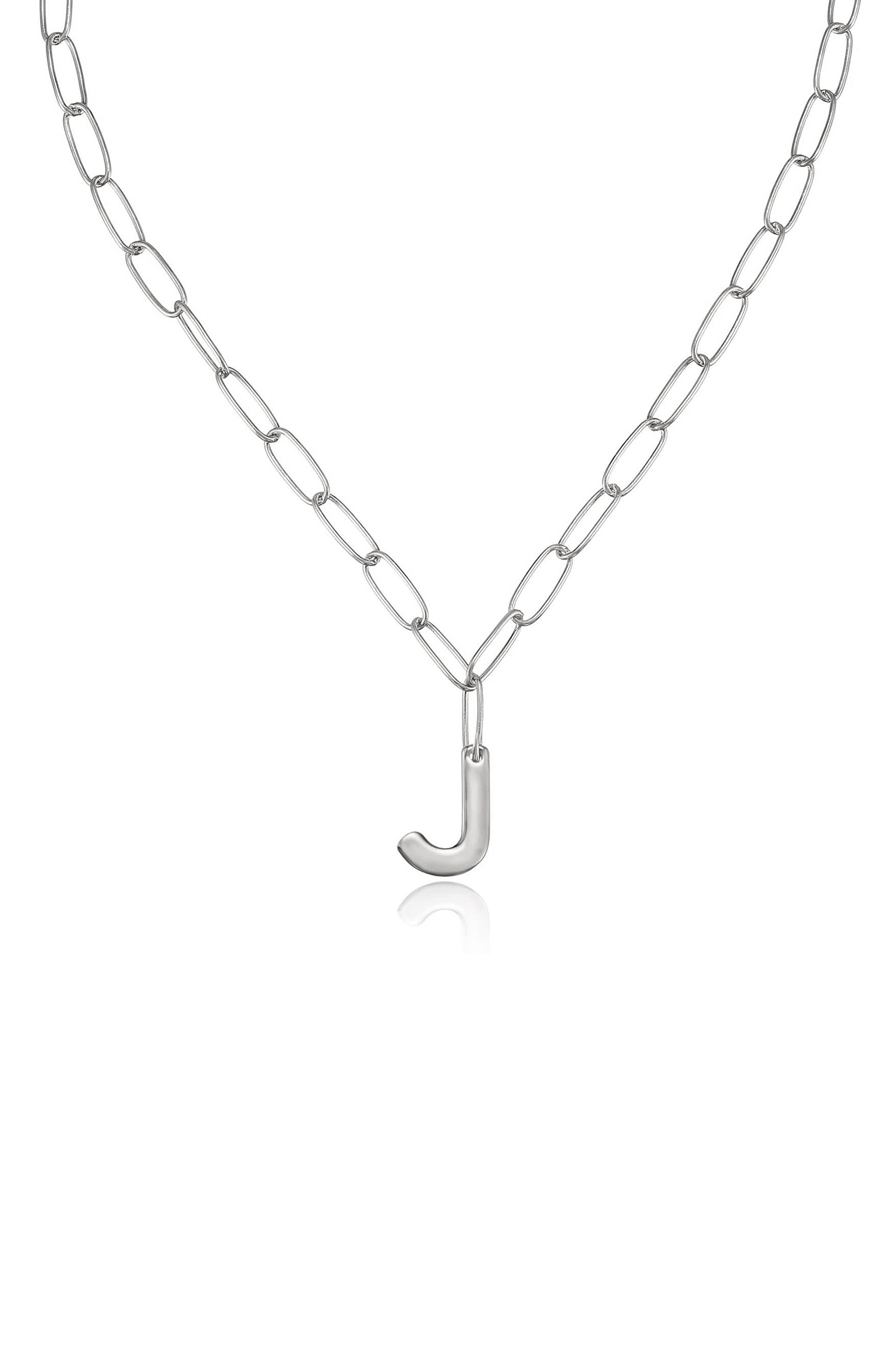 A silver chain necklace features elongated links with a stylized letter "J" pendant hanging at the center, against a plain white background that enhances its shine and simplicity.