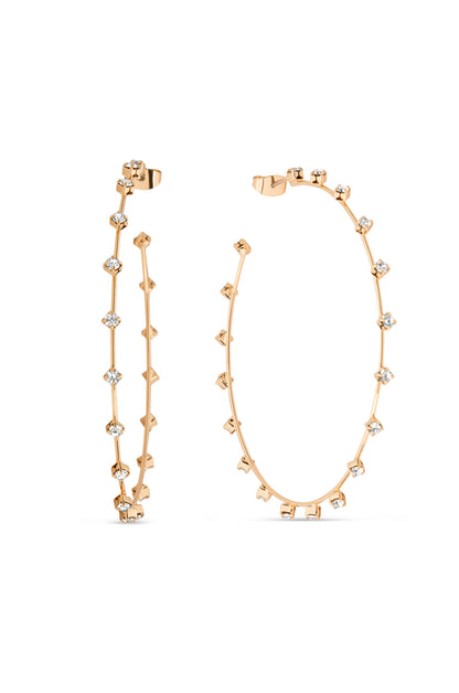 A pair of gold hoop earrings features small, alternating studs and transparent gemstones embedded along their length. They are elegantly displayed against a plain white background, showcasing their design.