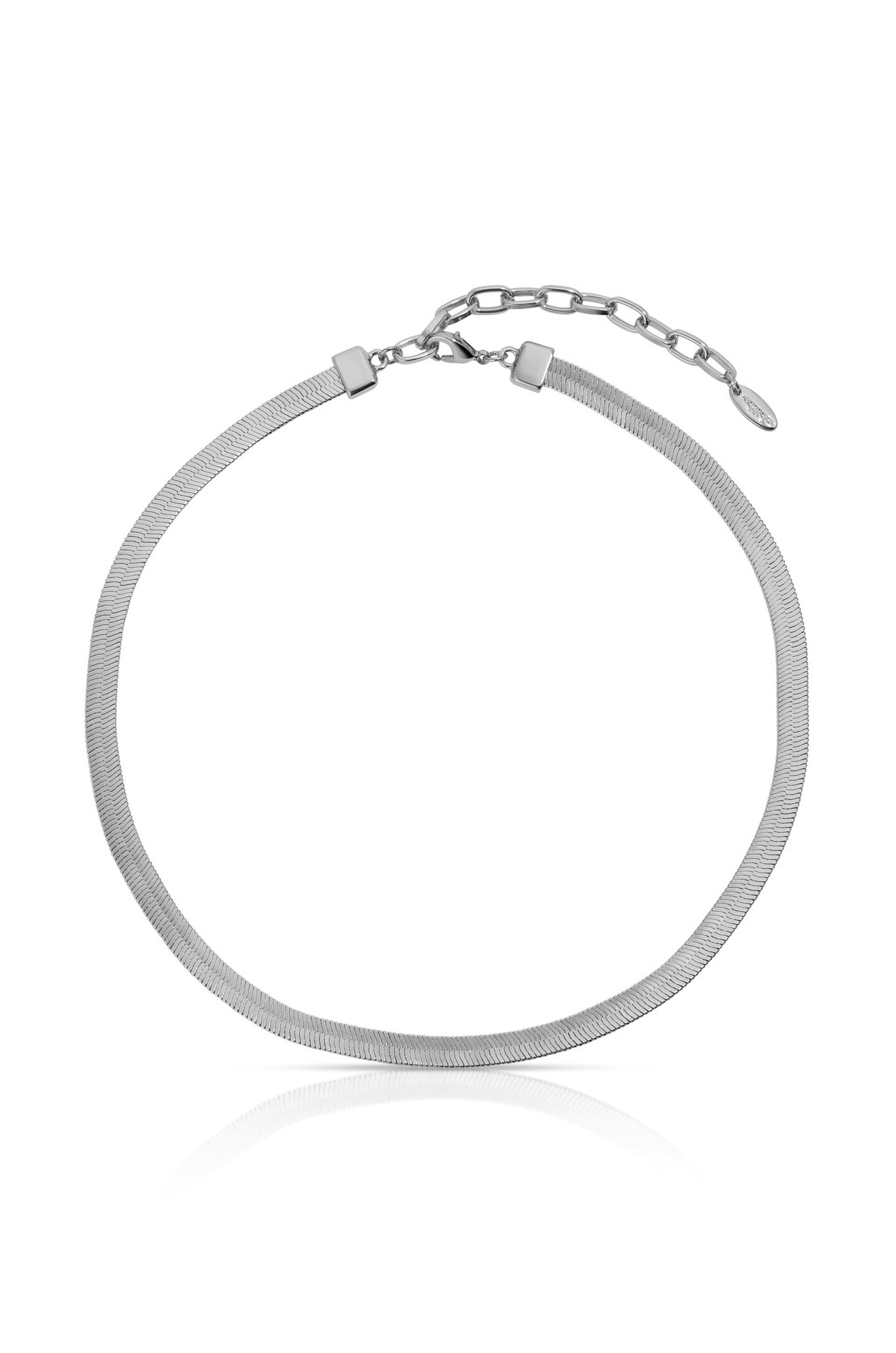 A sleek, silver necklace lies flat, showcasing its shiny, mesh-like design. It features a clasp and an adjustable chain for sizing, set against a plain, light background.