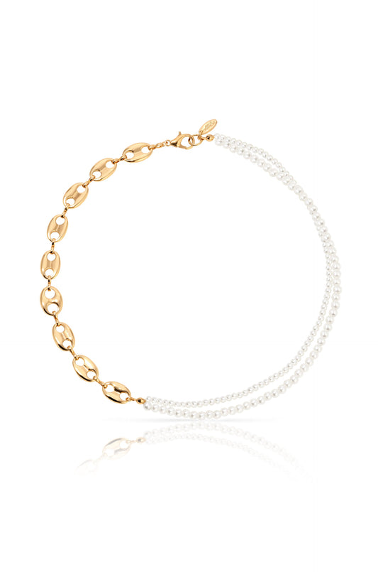 A gold-chain necklace with linked oval segments is adorned with two strands of small white pearls. It appears to rest on a reflective surface, highlighting its elegant design.