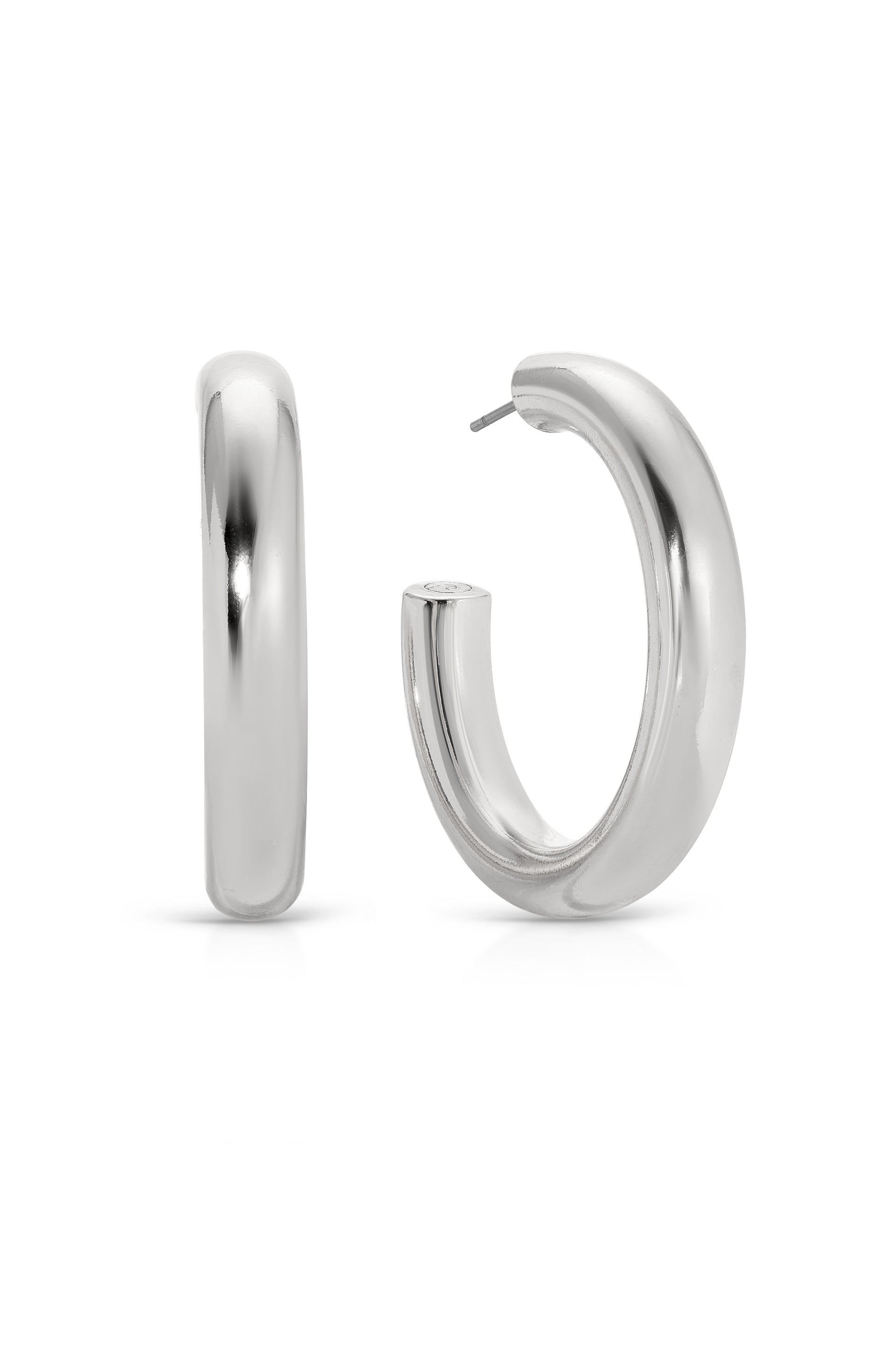 A pair of shiny silver hoop earrings stands upright against a white background. One earring is positioned sideways, while the other is partially turned to show its opening for fastening.