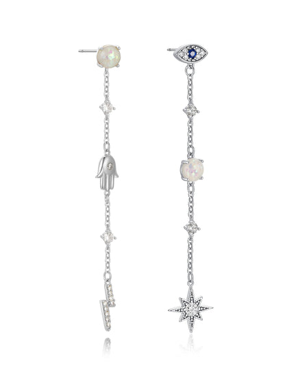 Dangle earrings feature a silver chain design. One side displays an opal stone with a hand charm, while the other has an eye motif with a star charm, set against a neutral background.