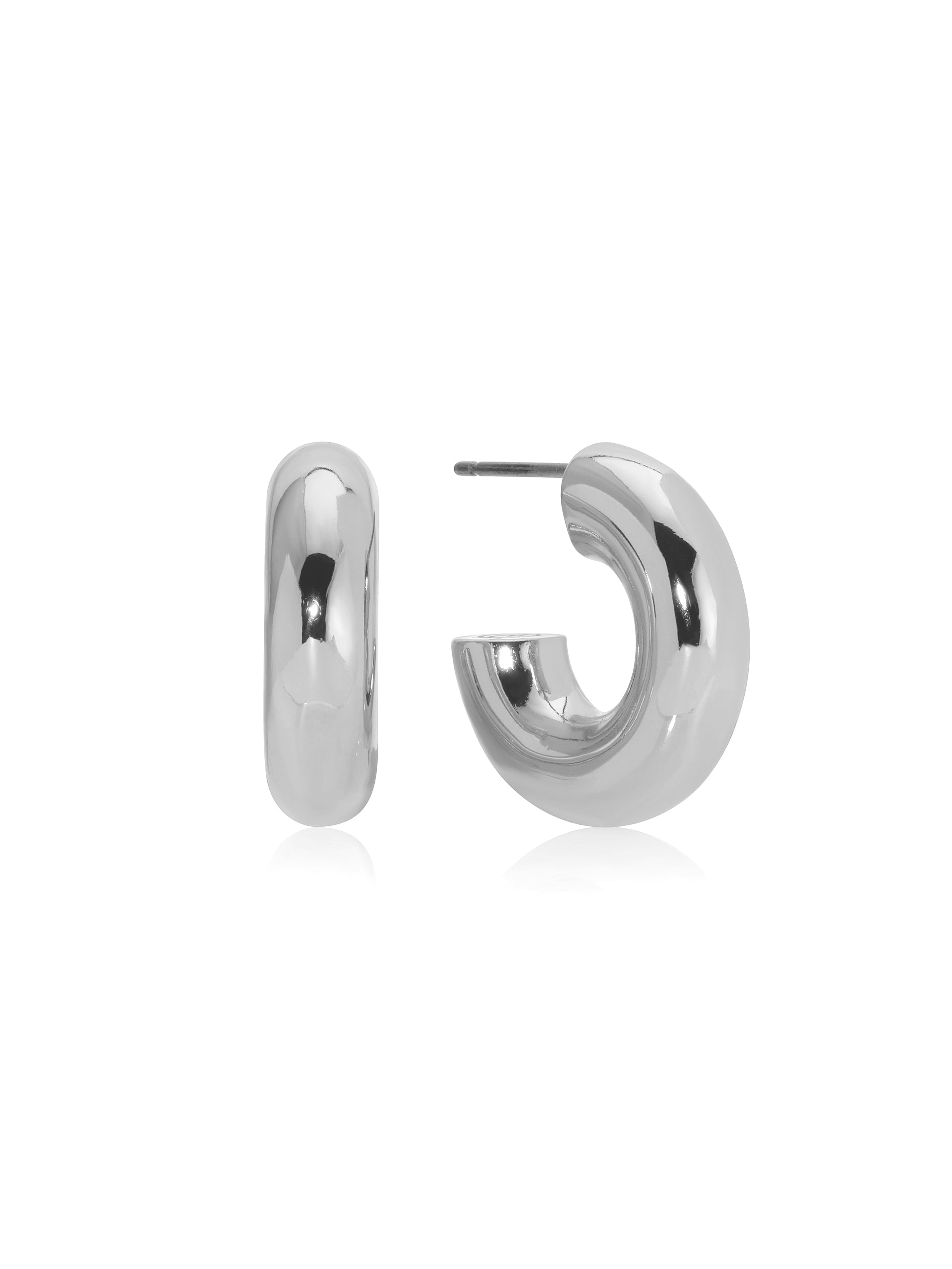 A pair of glossy silver hoop earrings lies on a neutral background, one earring displaying a complete loop while the other showcases an open design, reflecting light and creating a polished appearance.