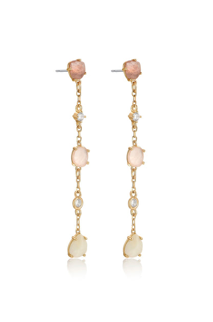 Dangling earrings showcase gold chain links adorned with pink and white stones. They reflect light, emphasizing their elegant design. The background is neutral, highlighting the jewelry's intricate craftsmanship.