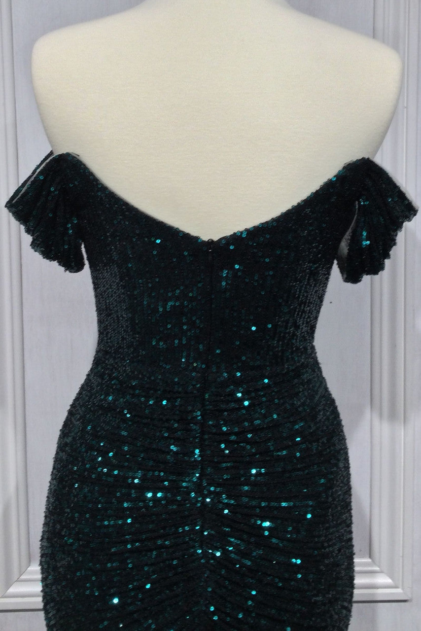 A fitted, off-the-shoulder, dark teal dress with sequins and ruched detailing. It is displayed on a mannequin against a white background, emphasizing its texture and shine.