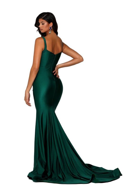 A woman wears a fitted, emerald green evening gown with a flowing train. She is posed from behind, showcasing the dress's silhouette and her shoulder-length hair, in a neutral background.