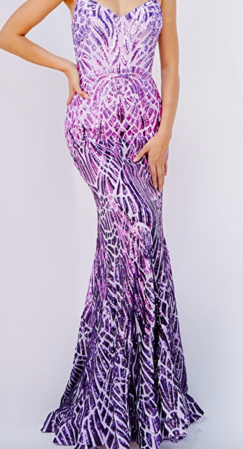 A fitted, floor-length dress features a vibrant purple and pink pattern with sparkling embellishments. The wearerâ€™s hand rests on her hip, showcasing the dress's contours against a plain white background.