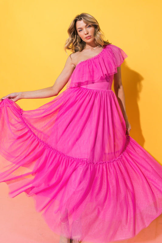 A model twirls in a flowing, vibrant pink dress with ruffles, set against a bright yellow background, creating a lively, cheerful atmosphere.